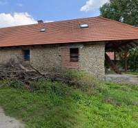A cottage in Zliechov with stone walls and a sloping red roof.