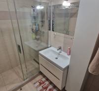 A bathroom with tiles and a shower in a 3-room apartment.