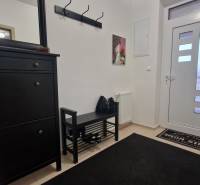 Dark furniture in the hallway of a 3-room apartment with a coat rack and a mirror.