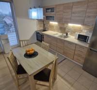A kitchen in a 3-room apartment with a wooden decor and a dining table.