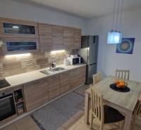 Kitchen in a 3-room apartment, wooden decor furniture, dining table with chairs.
