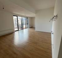Interior of a 2-room apartment with a wooden decor floor and large windows.