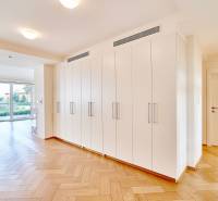 Interior of a 3-room apartment with white storage cabinets and a wooden decor floor.