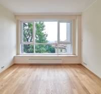 A room with a large window and a wooden decor floor in a 3-room apartment.