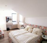 On Jánošíkova Street, in a family house, there is a cozy bedroom with a bed and decorative curtains.