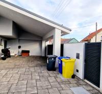A family house on Jánošíkova Street with a spacious yard, a garage, and waste bins.