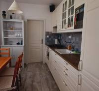 Kitchen in a 3-room apartment with a wooden table, cabinet, and plants.
