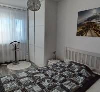 Bedroom in a 3-room apartment with a bed, wardrobe, and decorative photograph on the wall.