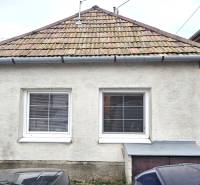 A family house in Dolné Orešany with a classic roof and two windows in the foreground.