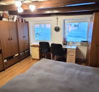 A room in a family house with wooden decor, a desk, and storage cabinets.