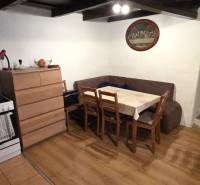 A kitchen in a family house with a corner sofa and a wooden decor floor.