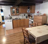 A kitchen with wooden furniture and a wooden decor floor in a family house.