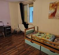 Children's room in a family house with a wooden decor floor and a work corner.