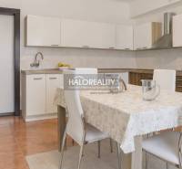 A kitchen in a family house with a white kitchen unit and a dining table with four chairs.