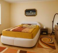 Bedroom with wood-patterned flooring in a family house, light walls, modern furnishings.