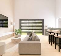 Living room in a family house with a wooden decor floor, a sofa, and a television on the wall.