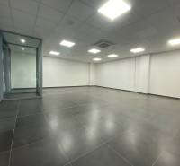 Commercial premises with a dark floor and a glass partition.