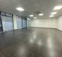 Commercial spaces with dark tiles, white walls, and glass displays.