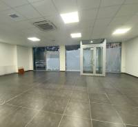 Commercial premises with dark tiles, glass doors, and a suspended ceiling.