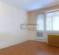 A room with a wooden decor floor in a 3-room apartment, a bright space with blinds.