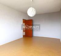 The room in the three-room apartment has a wooden decor floor and a white wall.