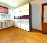 A room in a 3-room apartment with a wooden decor floor and a wardrobe.