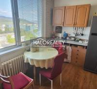 Kitchen in a studio apartment with a table, chairs, and a view from the window.
