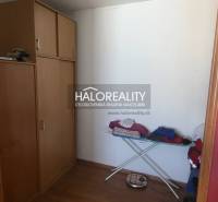 Wardrobe in a one-room apartment with wooden decor, storage cabinets, ironing board.