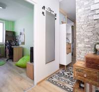 A hallway with colorful furniture, a green wall, and a wooden decor floor in a 2-room apartment.