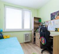 Children's room in a two-room apartment with a bed, desk, and floor with a wooden decor.