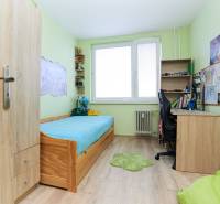Children's room with a bed, a desk, and a floor with a wooden decor in a two-room apartment.