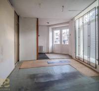 Interior of a building with glass doors and frosted blinds, carpeted floor.