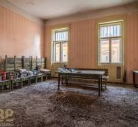 A worn-out room with benches and mess in an old building.