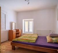 Bedroom with a bed, mirror, and wooden decor flooring.