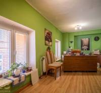Office with wooden floor decor, green walls, desk, and decorations.