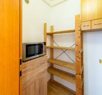 Pantry with shelves and a microwave, floor with wooden decor, 3-room apartment.