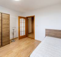 Bedroom with a wardrobe and a bed, 3-room apartment with a wooden decor floor.