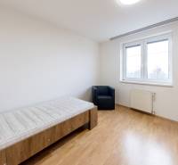 A bright room in a 3-room apartment with a wood-decor floor, a bed, and a window.