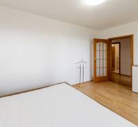 A bright room with wooden floor decor and a built-in wardrobe in a 3-room apartment.