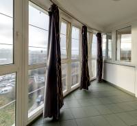 Enclosed loggia in a 3-room apartment with a view, tiles, large windows, curtains.