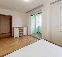Bedroom in a 3-room apartment with a wooden decor floor, access to the balcony.