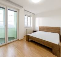 Bedroom with a bed and wooden decor flooring in a 3-room apartment.