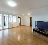 Living room with a television and wooden decor flooring in a three-room apartment.