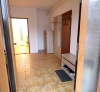 Entrance hall in a family house with tiles in soft shades and wooden furniture.