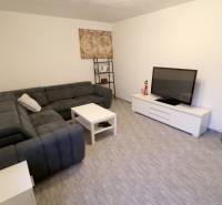 Living room in a family house with a large sofa, television, and a small table.