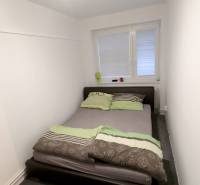 Bedroom with a bed in a family house, white walls, carpet.