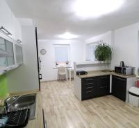 A kitchen in a family house with a wooden decor floor and plenty of storage space.