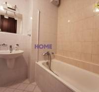 Bathroom in a 2-room apartment with a bathtub, sink, and mirror.