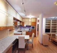 A kitchen unit with a dining table and a wooden decor floor in a 2-room apartment.