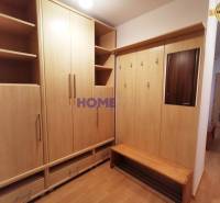 Entrance hall in a 2-room apartment with wooden decor furniture and a mirror.